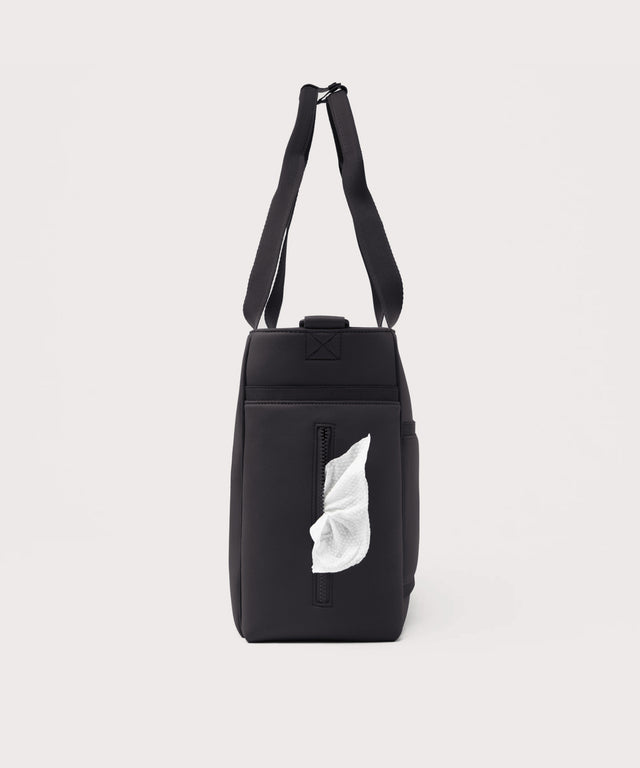 Dagne Dover large Wade Diaper Tote in black seen from the side, with a wet wipe poking out of the slip pocket.
