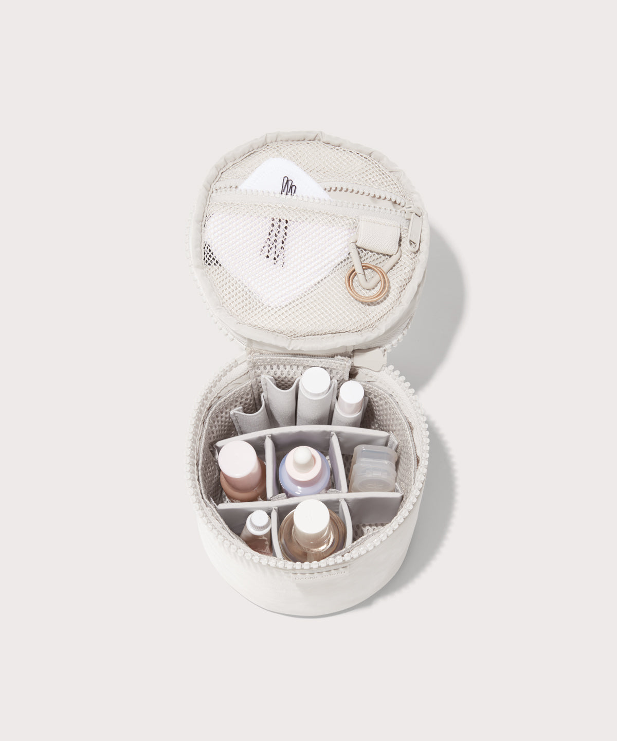 Dagne Dover small Mila Toiletry Pouch in white unzipped filled with toiletry products.
