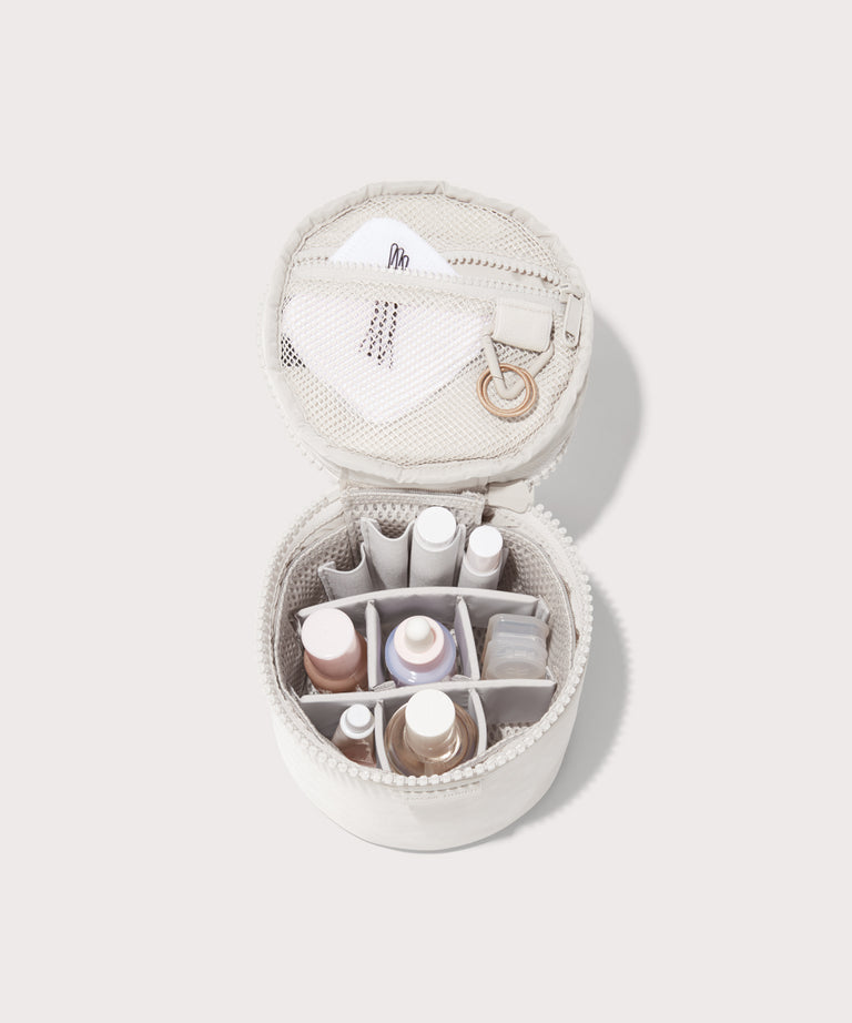 Dagne Dover small Mila Toiletry Pouch in white unzipped filled with toiletry products.
