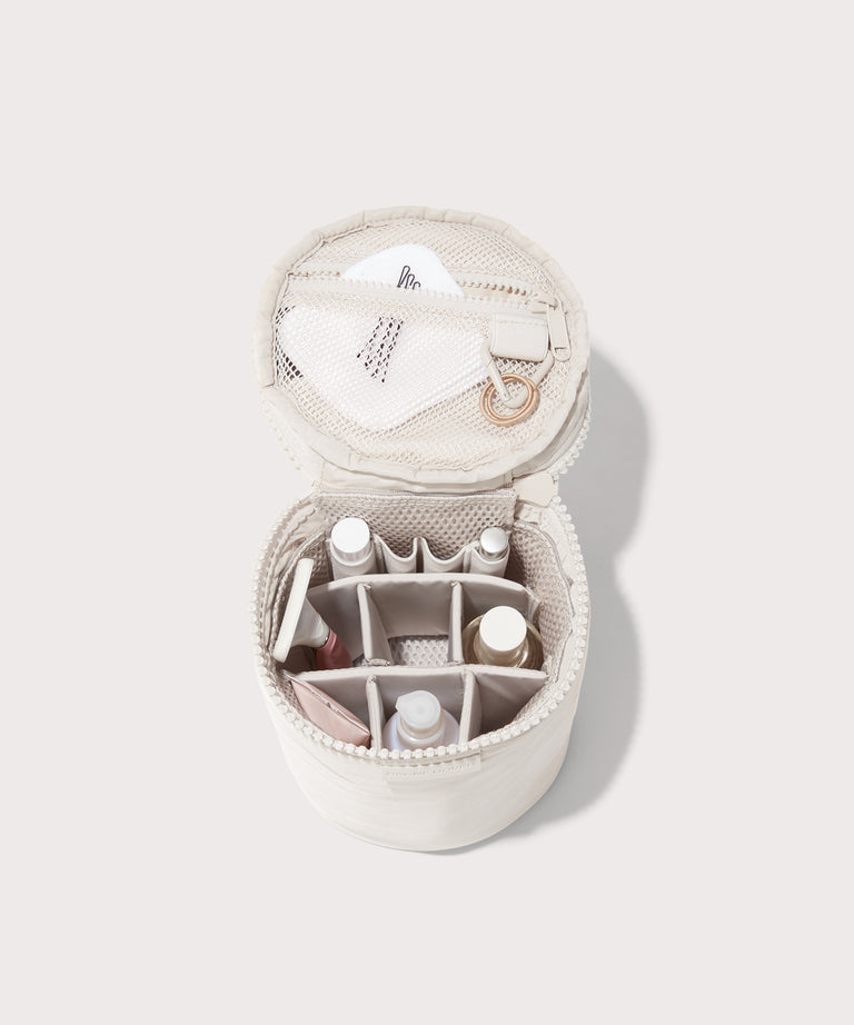 Dagne Dover large Mila Toiletry Pouch in white unzipped filled with toiletry products.
