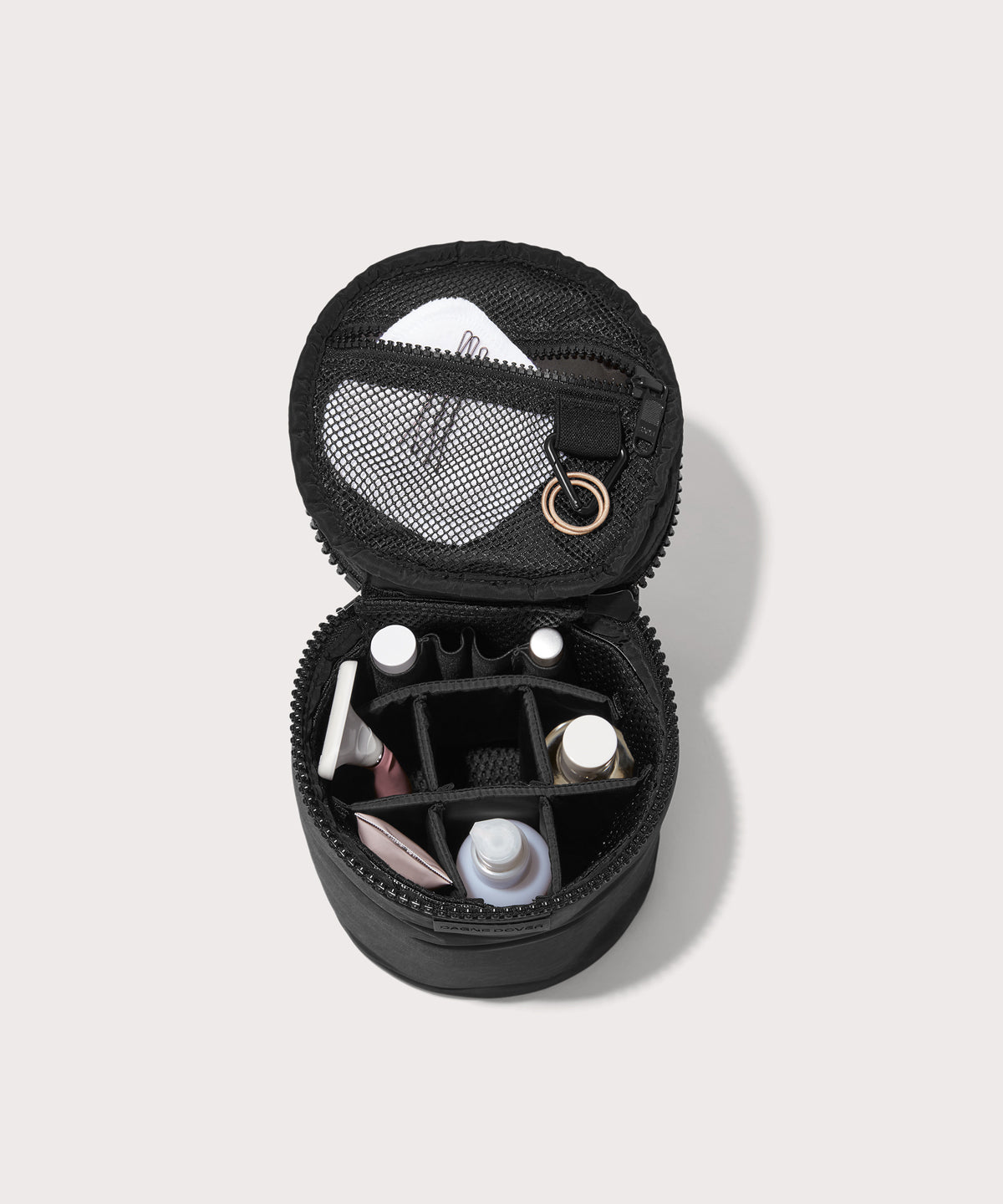 Dagne Dover large Mila Toiletry Pouch in black unzipped filled with toiletry products.
