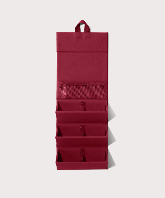 Dagne Dover Remi foldable glasses holder in spice red hung up.
