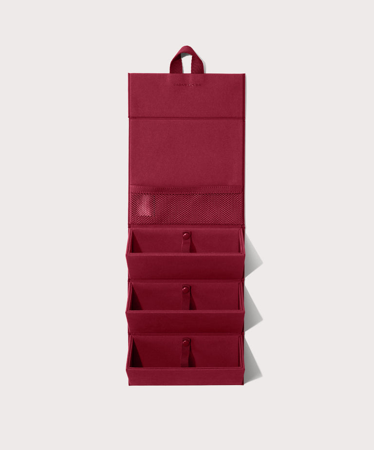 Dagne Dover Remi foldable glasses holder in spice red hung up.
