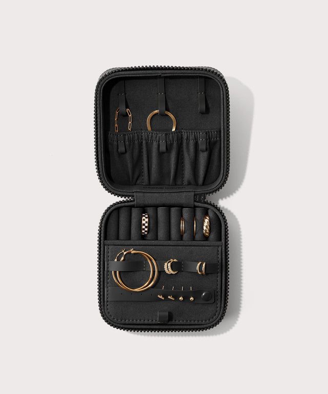 Dagne Dover Large Frankie Jewelry Case in black, seen open from above with jewelry inside the interior compartment.