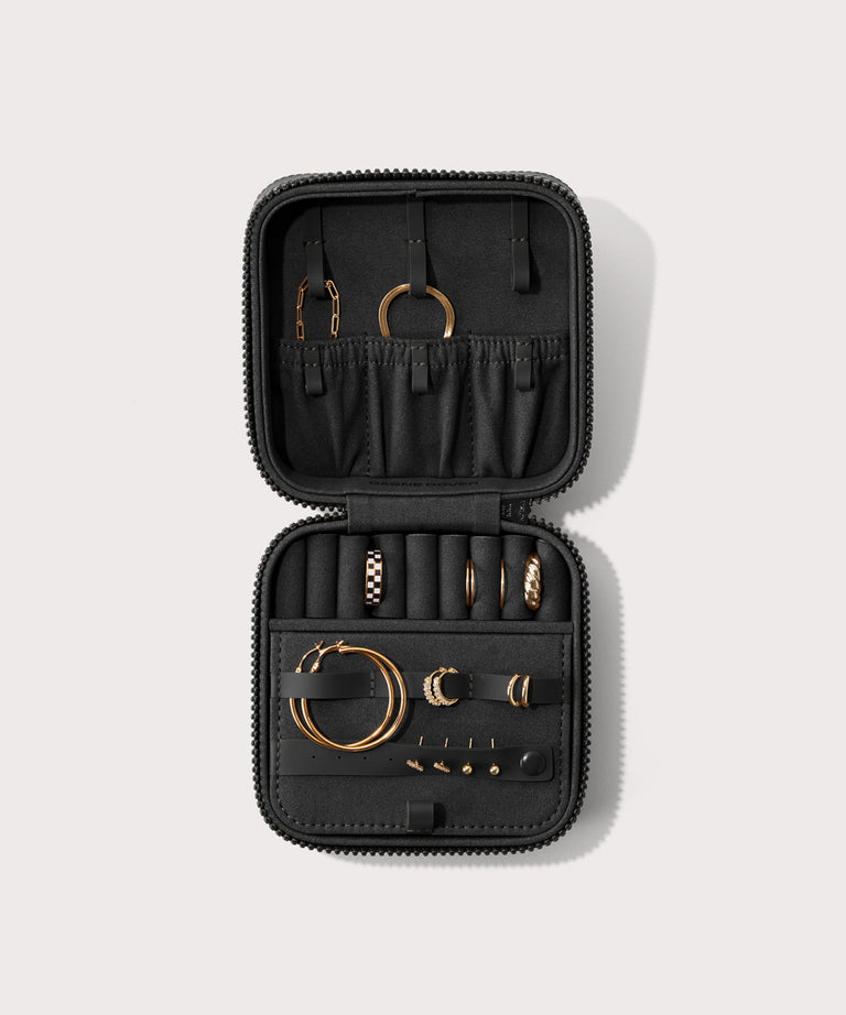 Dagne Dover Large Frankie Jewelry Case in black, seen open from above with jewelry inside the interior compartment.