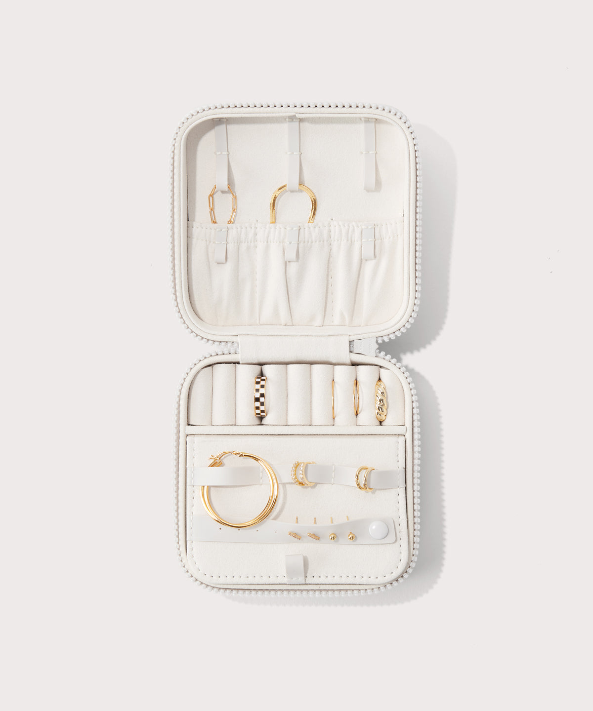 Dagne Dover Large Frankie Jewelry Case in white, seen open from above with jewelry inside the interior compartment.