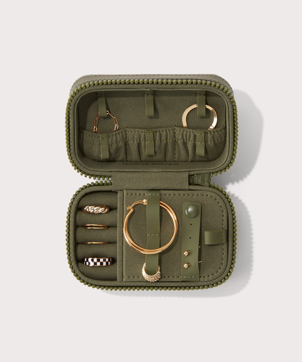 Dagne Dover small Frankie Jewelry Case in dark green, seen open from above with jewelry inside the interior compartment.