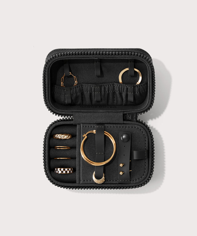 Dagne Dover small Frankie Jewelry Case in black, seen open from above with jewelry inside the interior compartment.