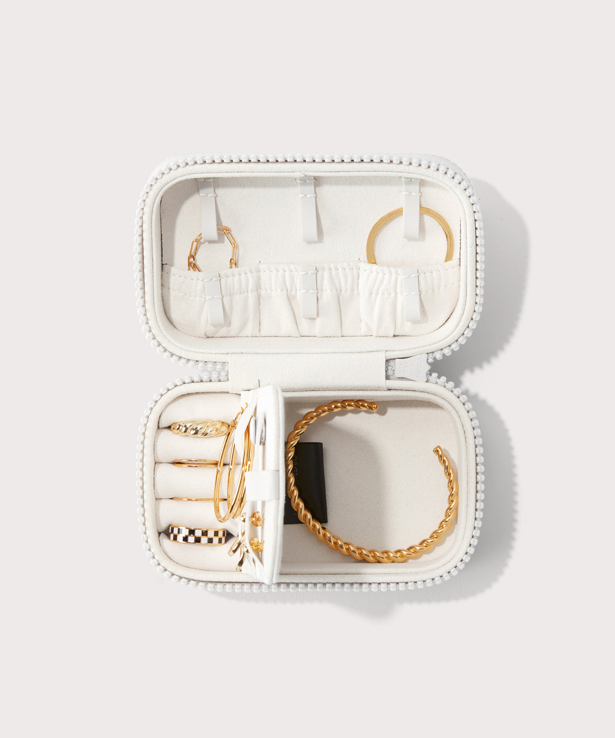 Dagne Dover small Frankie Jewelry Case in white, seen open from above with jewelry inside the interior compartment.