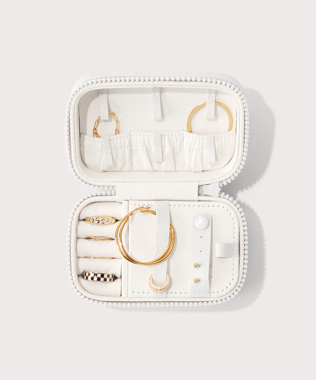 Dagne Dover small Frankie Jewelry Case in white, seen open from above with jewelry inside the interior compartment.