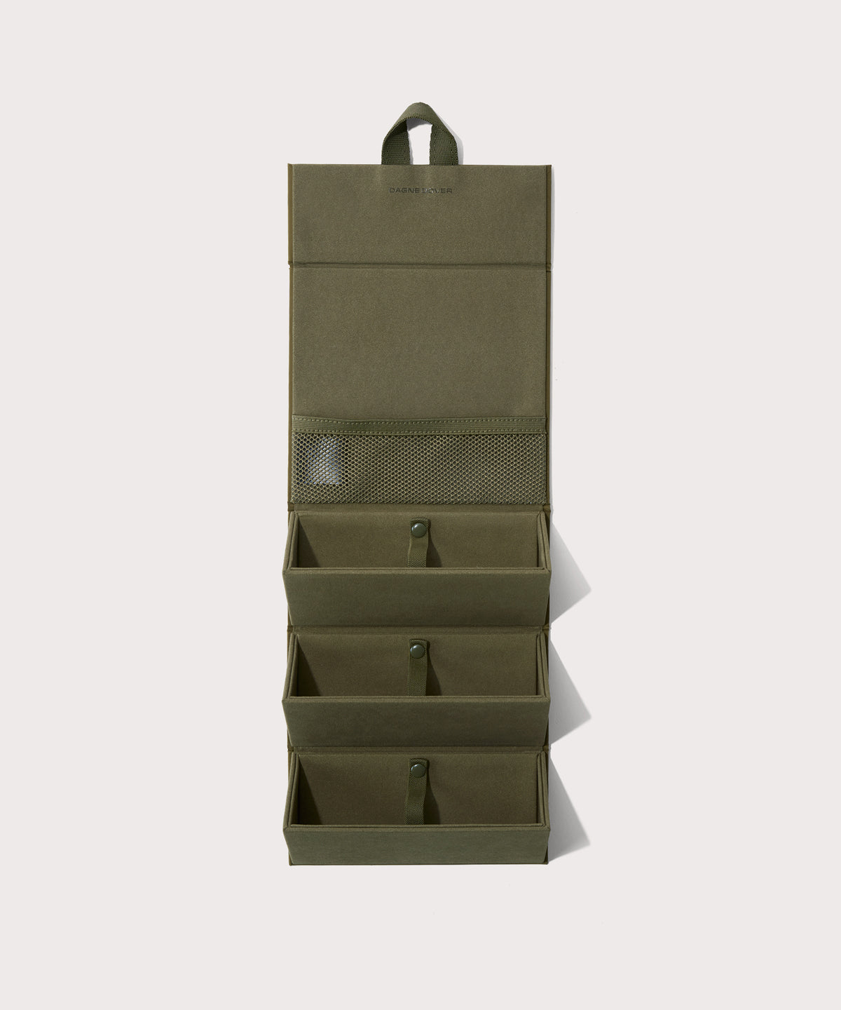 Dagne Dover Remi foldable glasses holder in dark green hung up.
