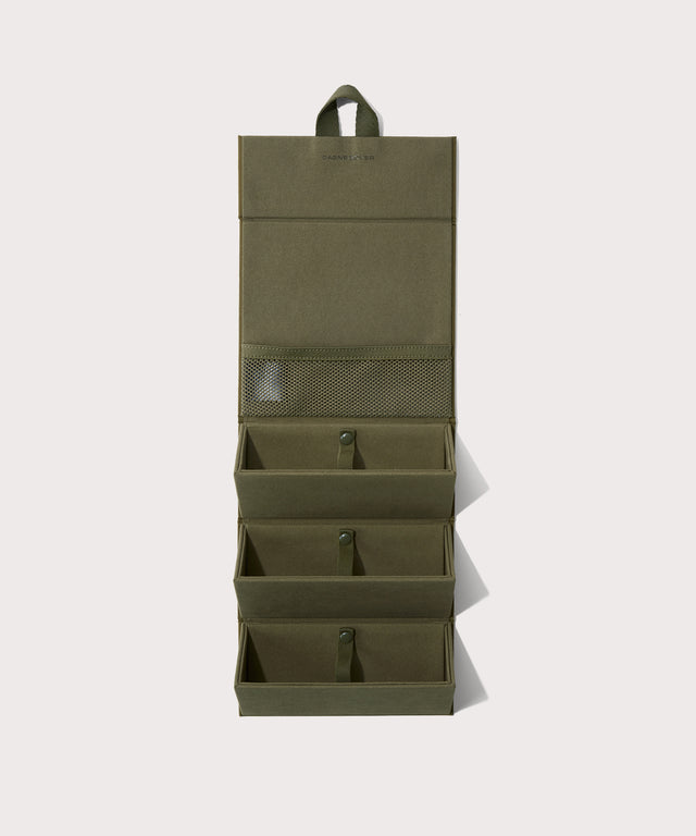 Dagne Dover Remi foldable glasses holder in dark green hung up.
