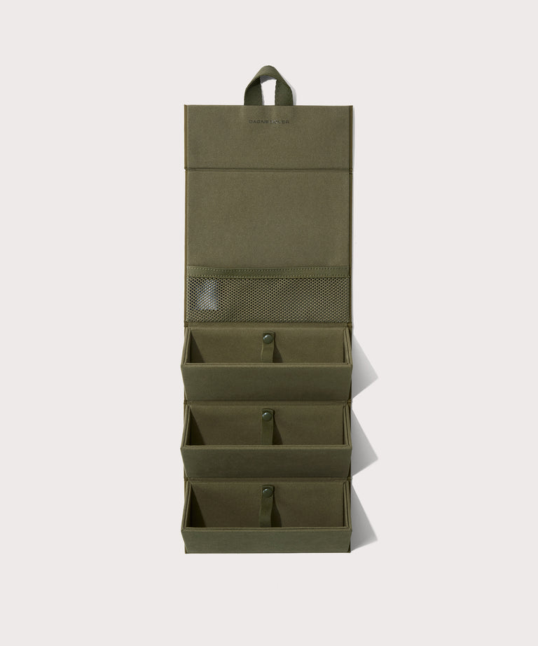 Dagne Dover Remi foldable glasses holder in dark green hung up.
