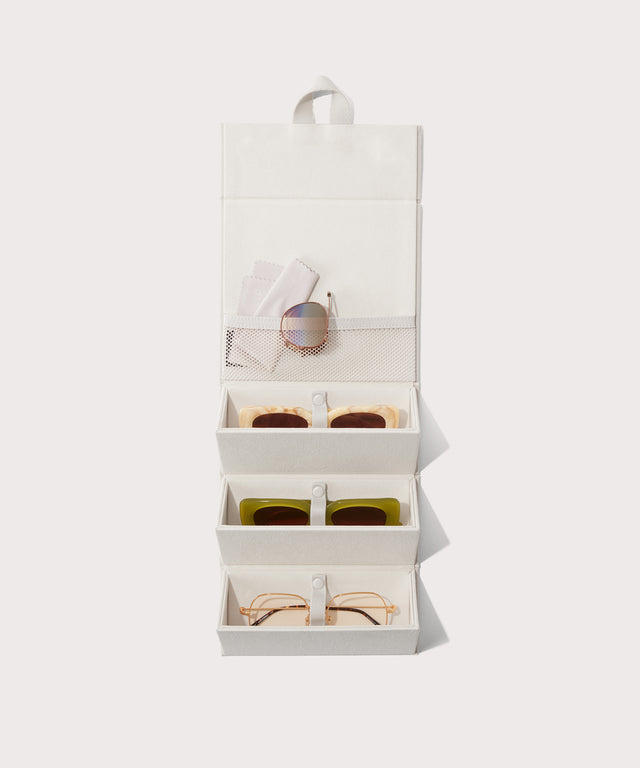 Dagne Dover Remi foldable glasses holder in white hung up and holding glasses.
