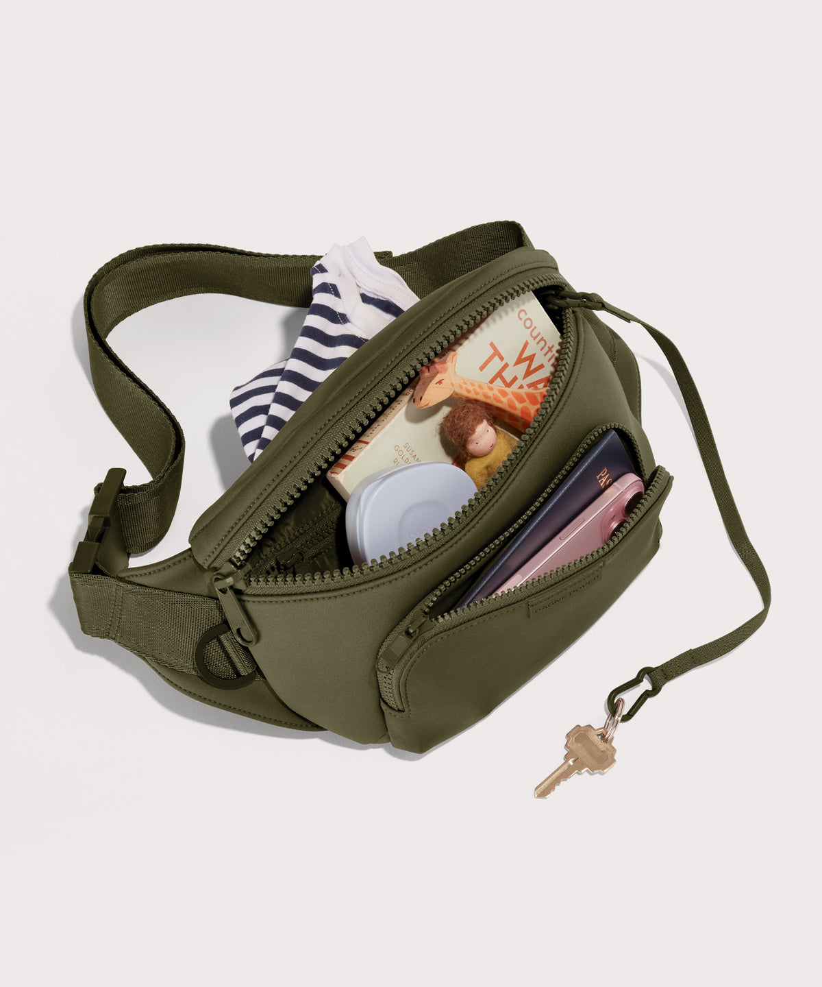 Dagne Dover jax large Fanny Pack in dark green unzipped, exposing the interior pockets.