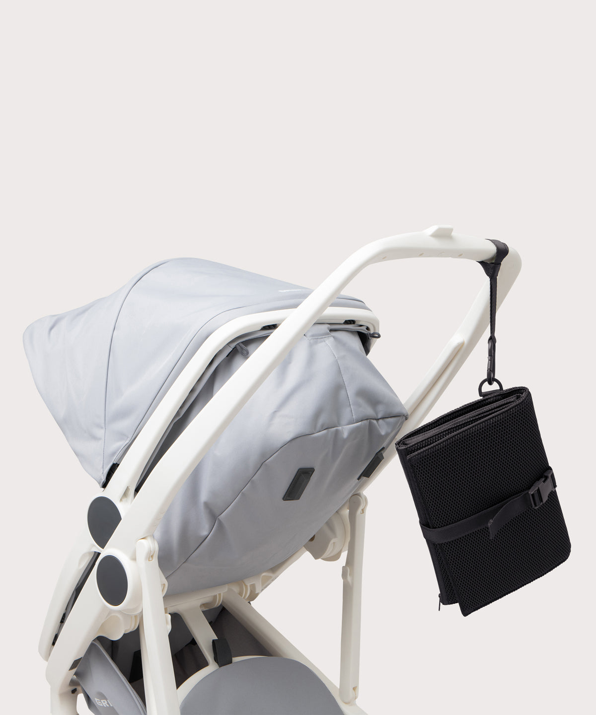 Dagne Dover Joey Changing Kit in black strapped to the handle of a stroller.
