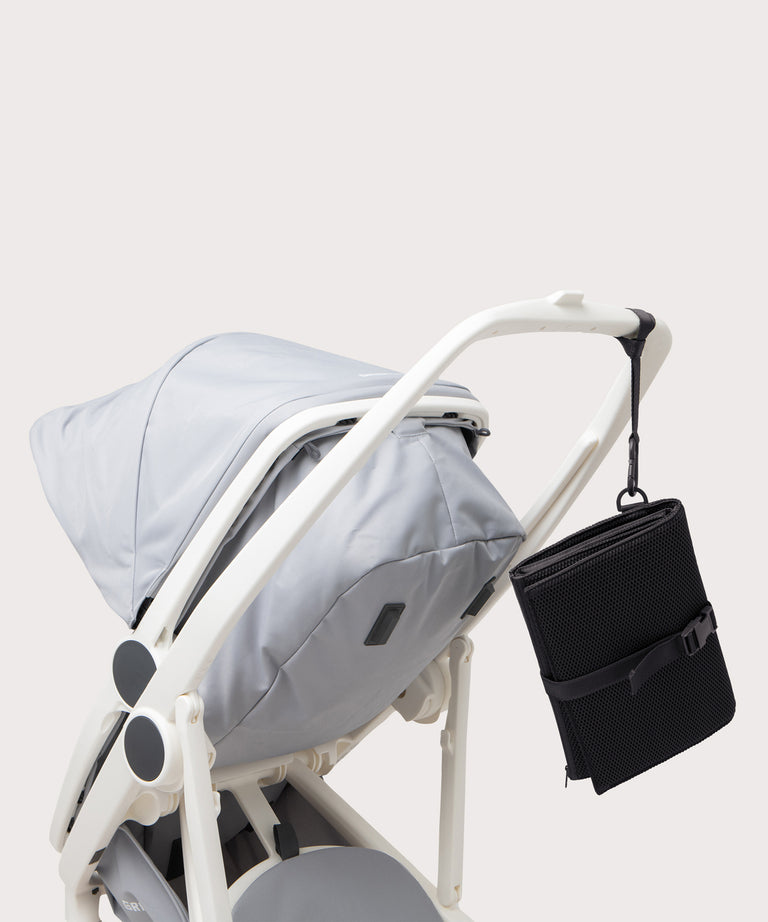 Dagne Dover Joey Changing Kit in black strapped to the handle of a stroller.
