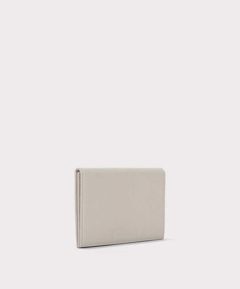 Dagne Dover Accordion Travel Wallet in white seen from an angle.
