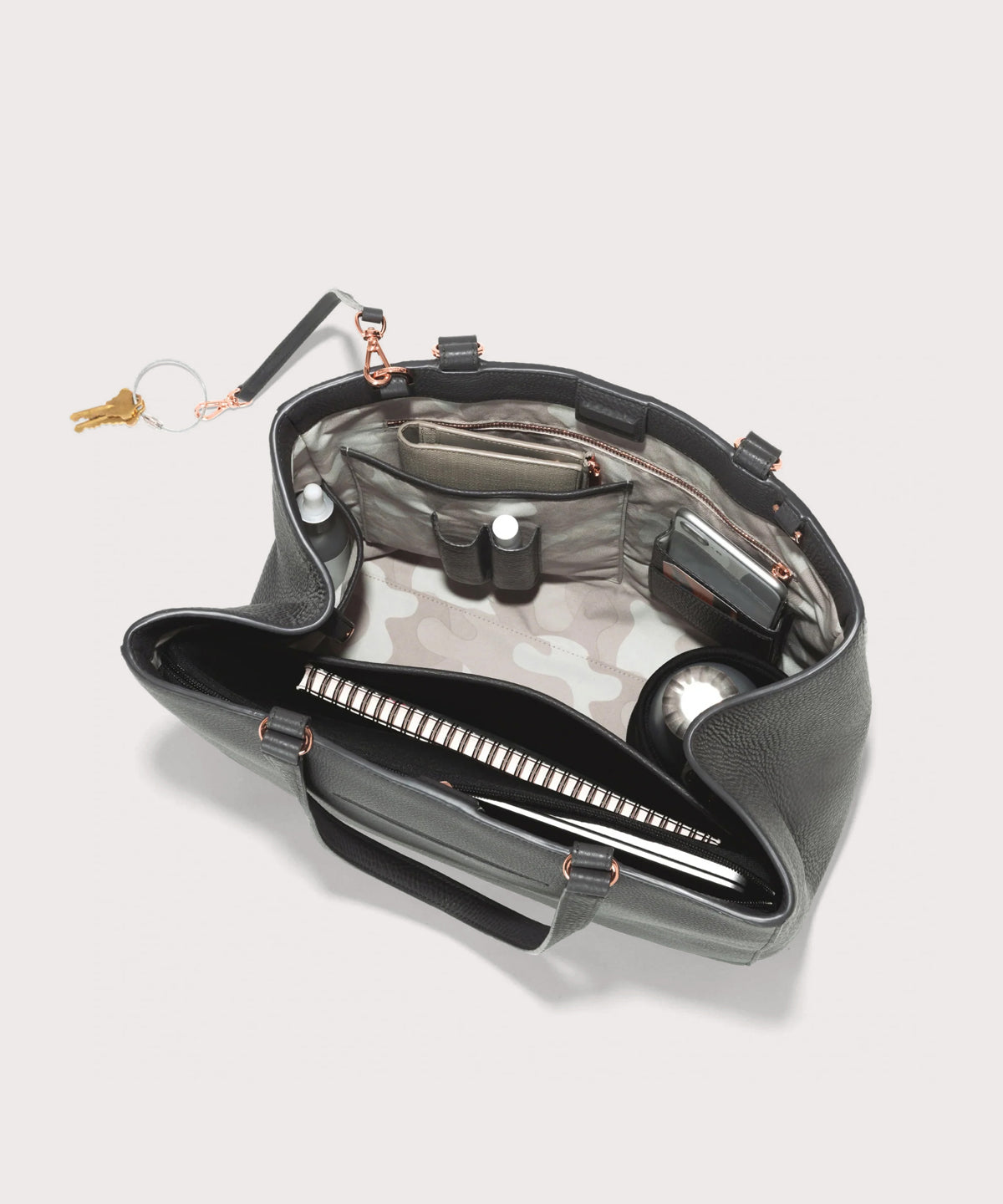 hover - Dagne Dover large Allyn Tote in grey with objects inside the interior pockets.
