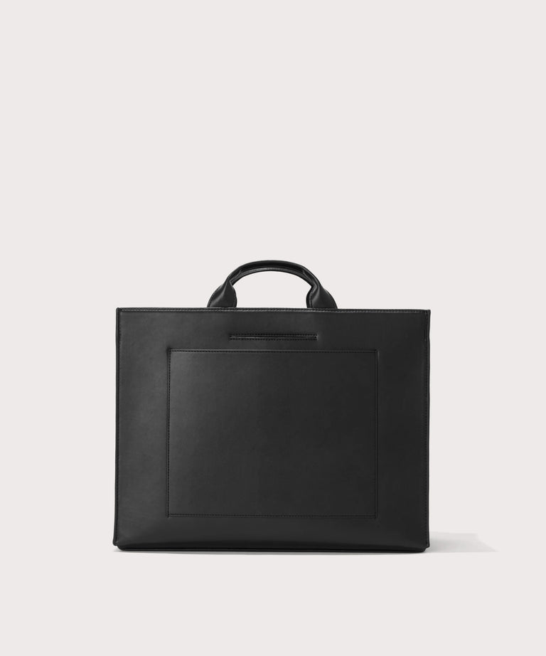 Dagne Dover large vegan Daily Tote in black revealing the exterior phone pocket and exterior luggage sleeve.
