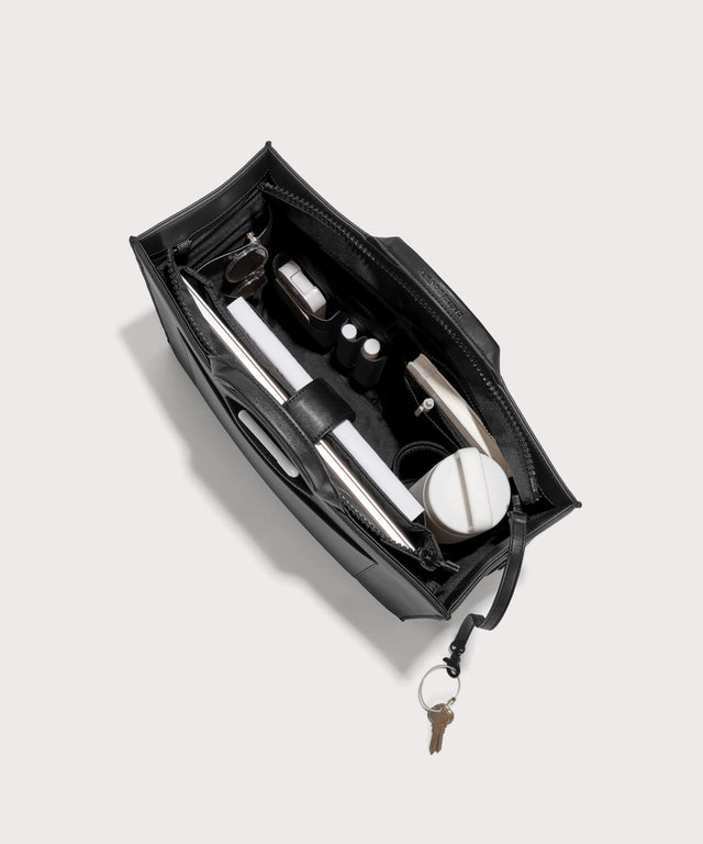 hover - Dagne Dover large vegan Daily Tote in black from above, revealing the interior zipper, interior slip pockets, and padded laptop sleeve.
