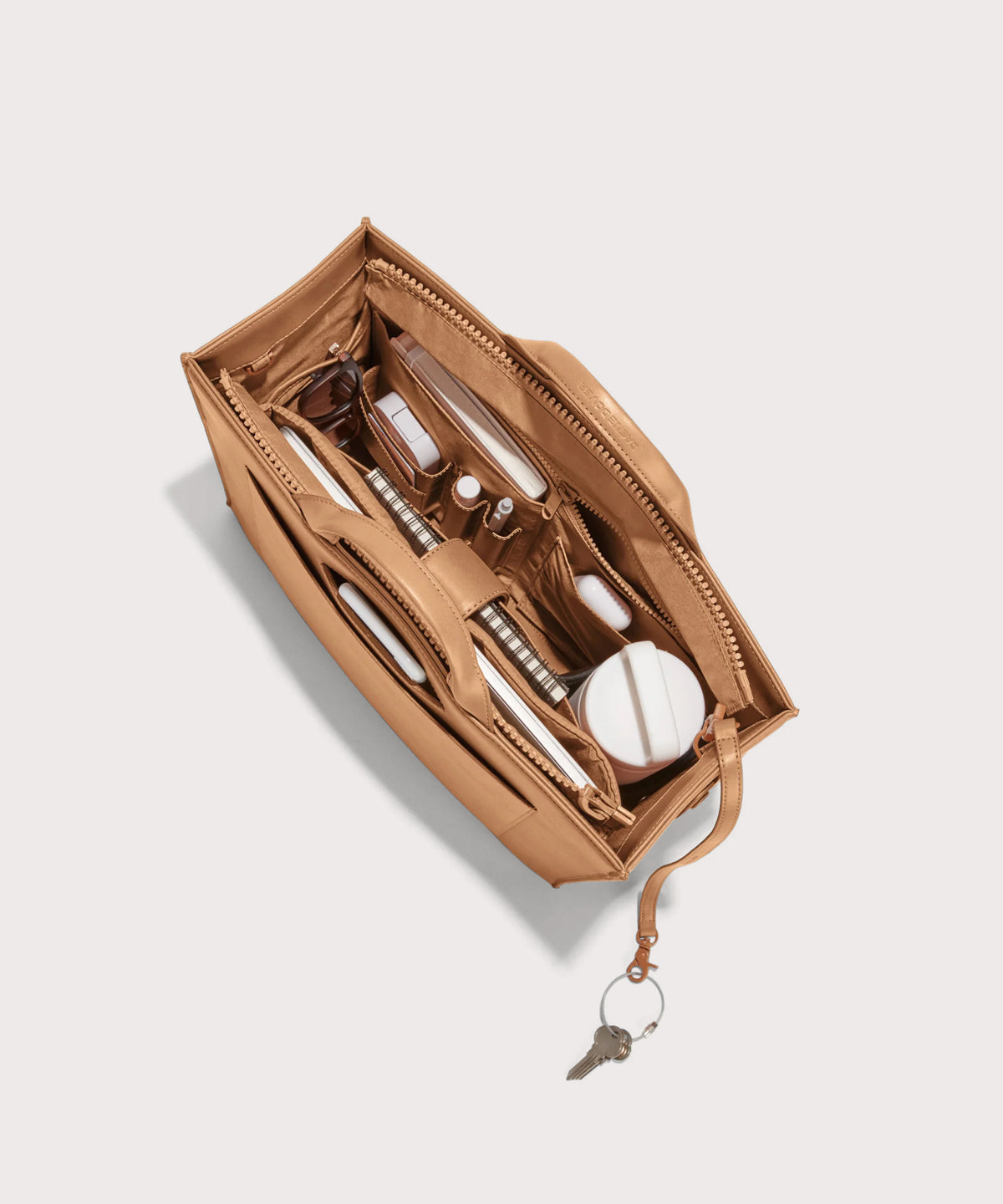 hover - Dagne Dover medium vegan Daily Tote in brown from above, revealing the interior zipper, interior slip pockets, and padded laptop sleeve