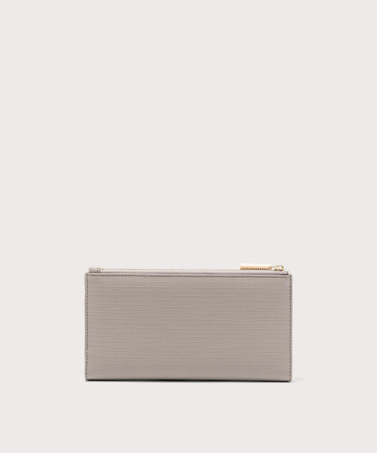 Dagne Dover Slim Wallet in beige seen from the back.
