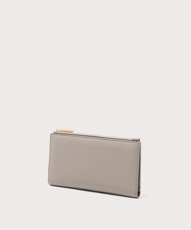 Dagne Dover Slim Wallet in beige seen from an angle.

