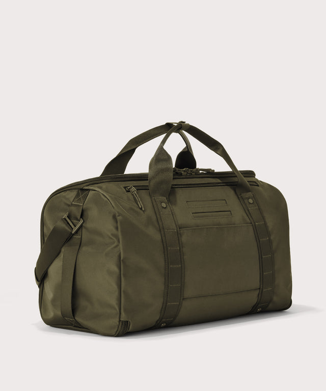 3/4 back view of Monaco garment duffle in dark green showing back zippered tech pocket and phone/passport pockets
