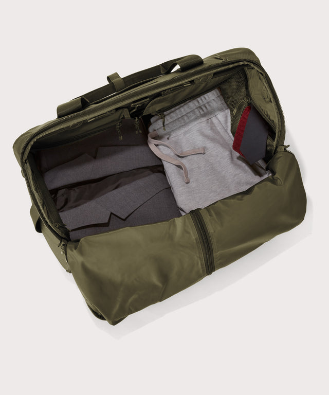 Top down of Monaco garment duffle in dark green with packing cube on the right side.
