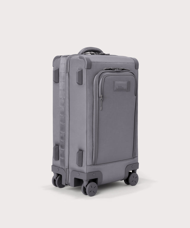 ¾ front view of Seattle carry-on rolling luggage 23.5” in light grey with front flap opened. Caption: Interior slip pocket fits most 16
