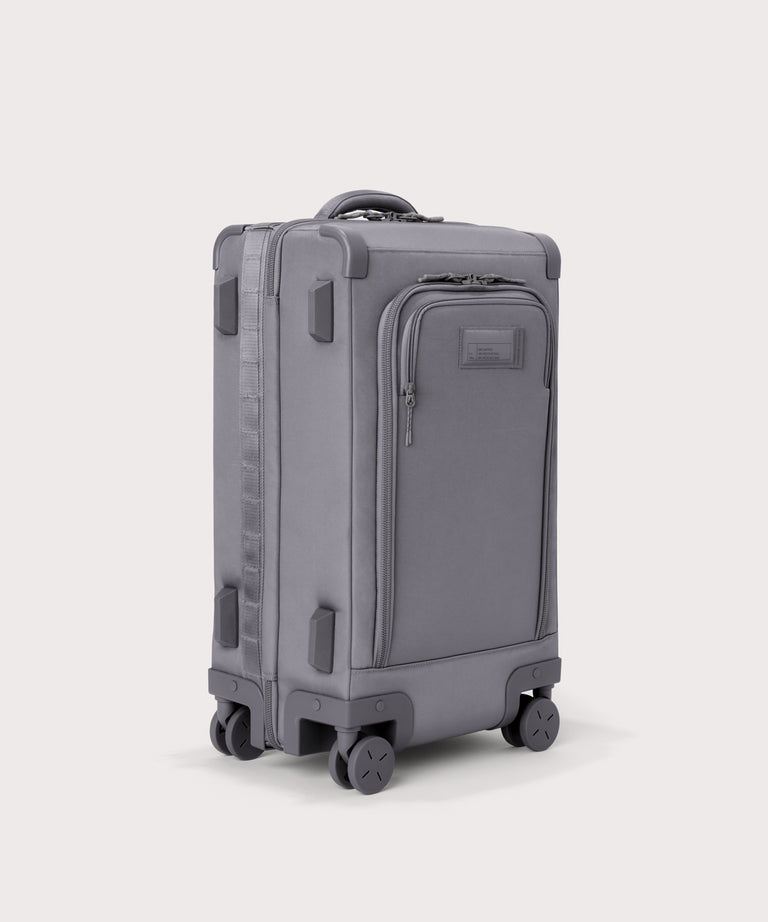 ¾ front view of Seattle carry-on rolling luggage 23.5” in light grey with front flap opened. Caption: Interior slip pocket fits most 16" laptops
