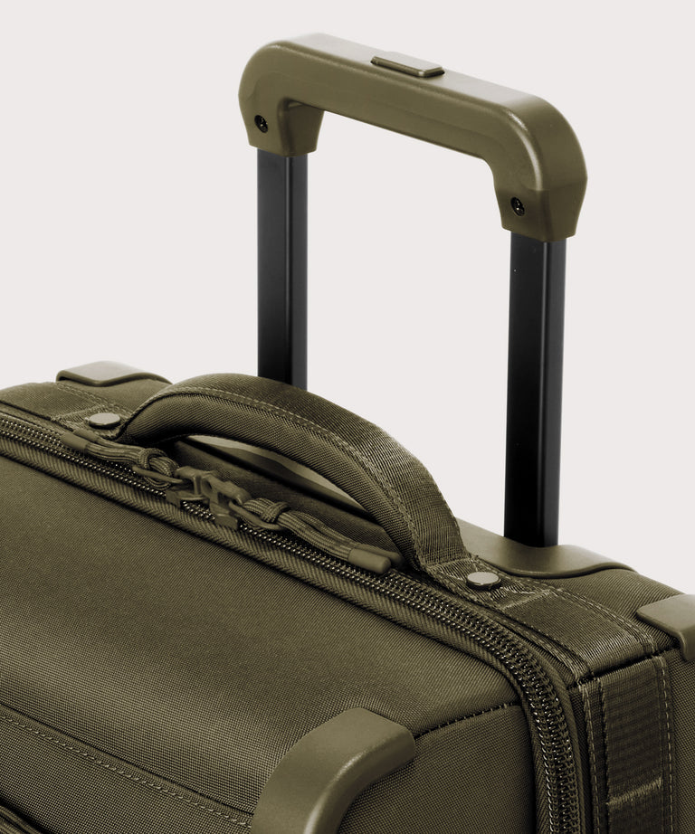 Detail shot of Seattle carry-on rolling luggage 20.5” in dark green extended luggage handle and puffy handle
