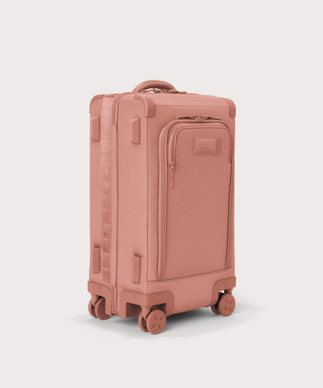 ¾ front view of Seattle carry-on rolling luggage 23.5” in warm dust pink with front flap opened. Caption: Interior slip pocket fits most 16