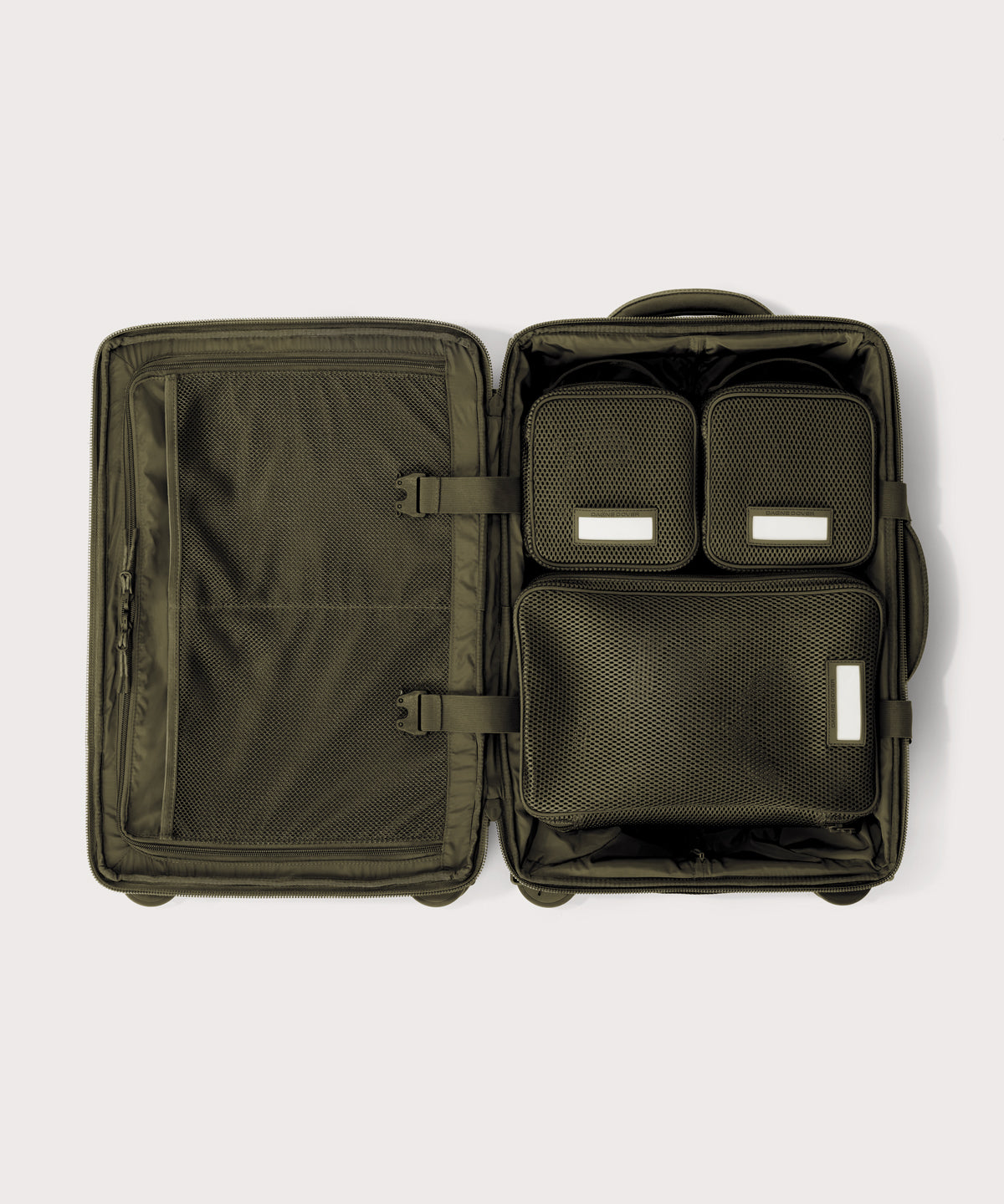 Top down of Seattle carry-on rolling luggage 20.5” in dark green with interior divider zipped and packing cubes packed into the right side. 
