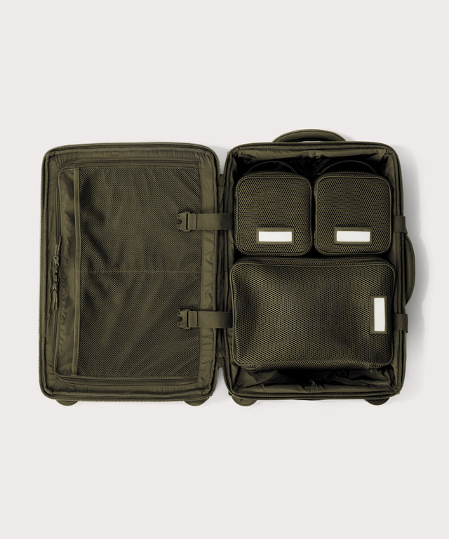 Top down of Seattle carry-on rolling luggage 20.5” in dark green with interior divider zipped and packing cubes packed into the right side. 
