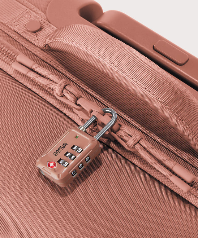 Detail shot of Seattle carry-on rolling luggage 20.5” in warm dust pink lockable zipper heads. Lock not included. 