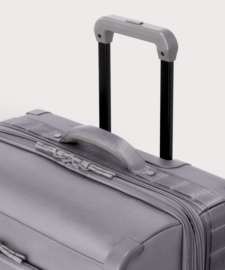 Detail shot of Sydney checked rolling luggage 28.5” in light grey extended luggage handle and puffy handle