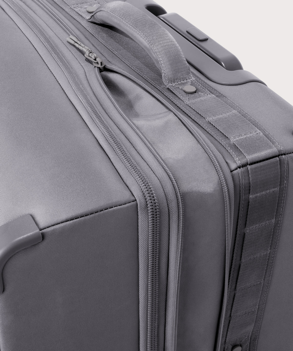 Detail shot of Sydney checked rolling luggage 28.5” in light grey lockable zipper heads. Lock not included. 
