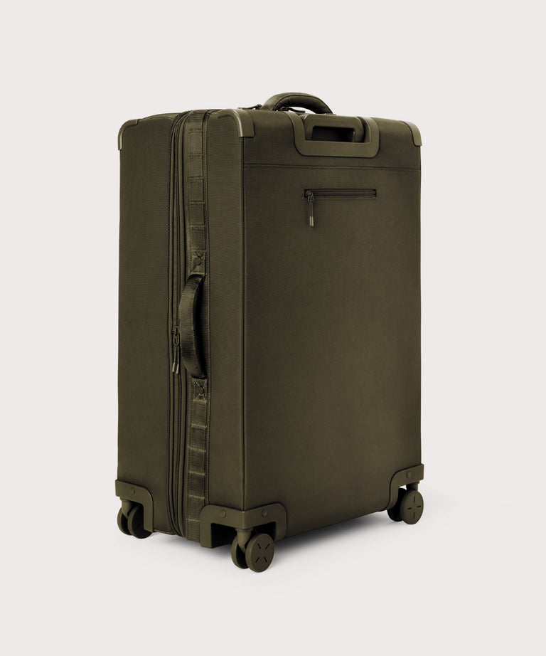 3/4 back view of Sydney checked rolling luggage 28.5” in dark green showing side handle and back zippered phone/passport pocket
