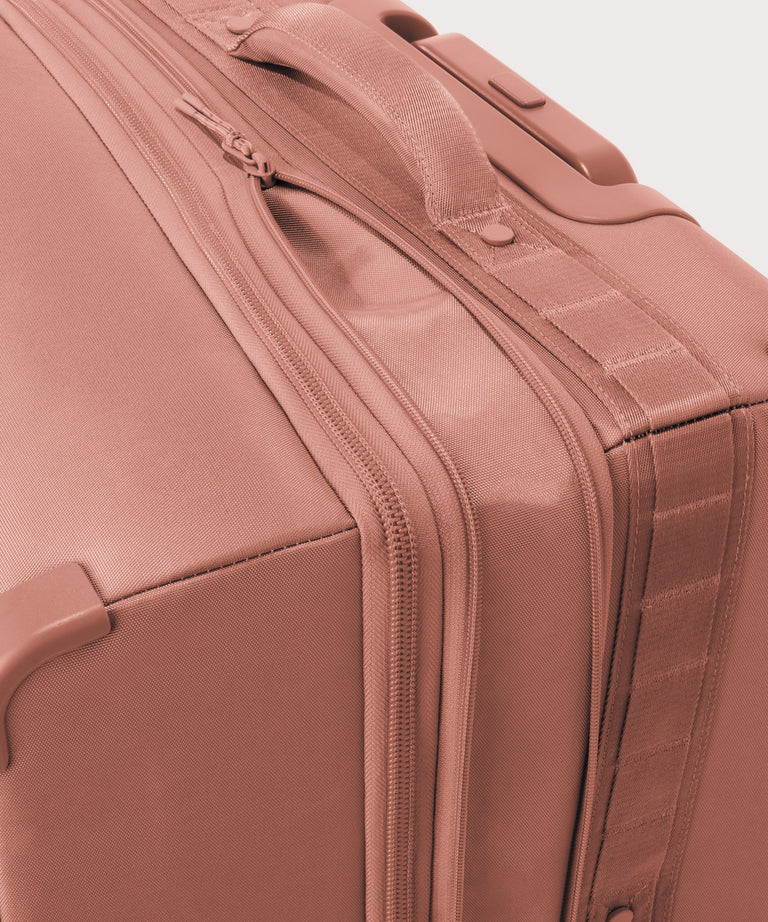 Detail shot of Sydney checked rolling luggage 28.5” in warm dust pink expandable zipper feature
