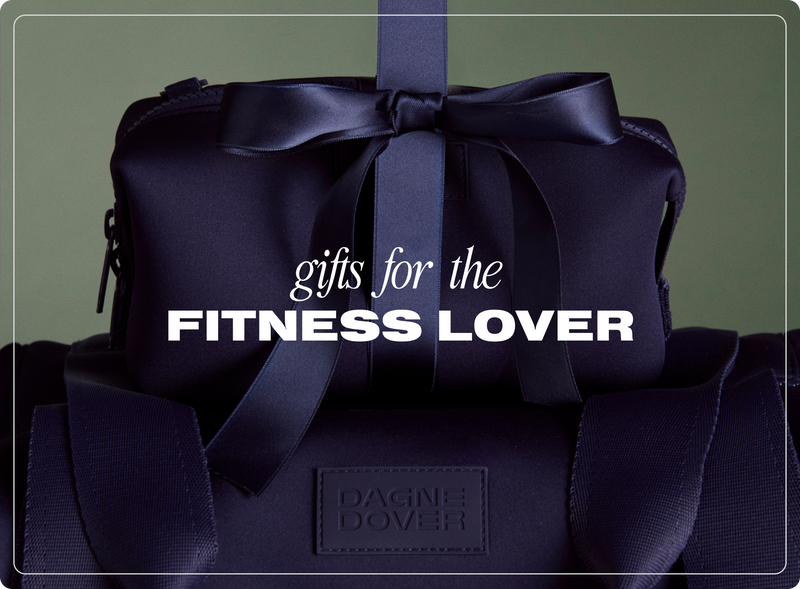 Navy blue bag with a bow and 'Dagne Dover' branding, labeled 'Gifts for the Fitness Lover' on a dark green background.